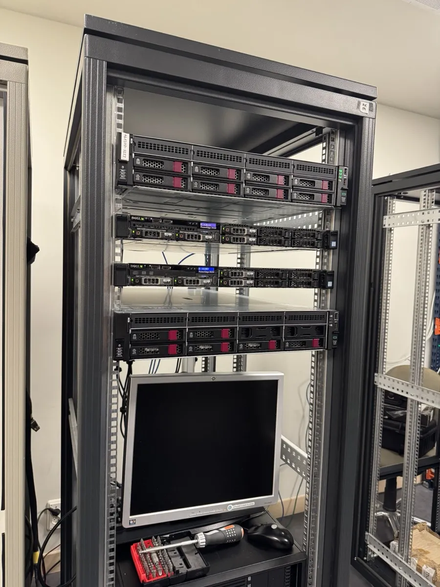 Rack de servidores montados en bastidor, con cableado recogido por detrás y monitor de consola en la balda inferior.